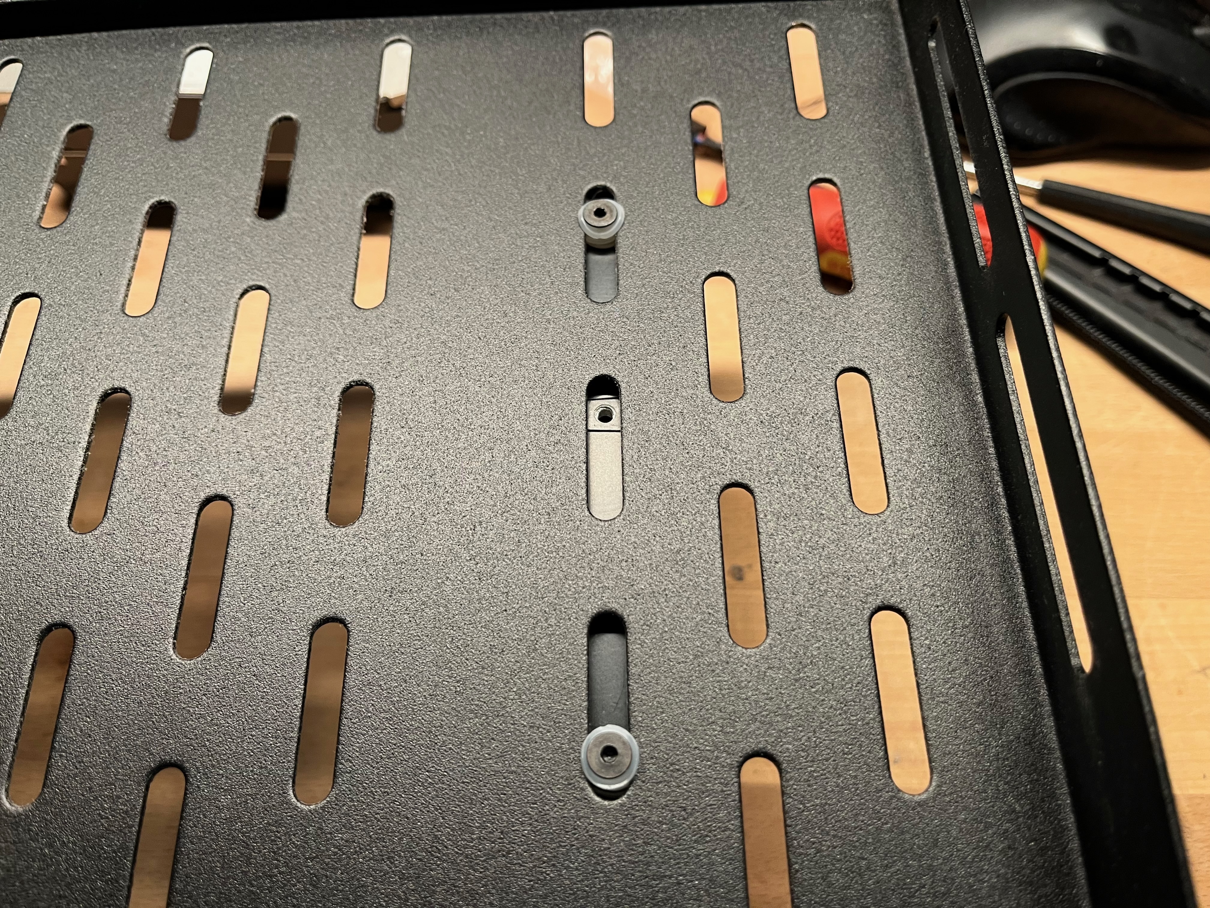 Rack shelf ventilation holes with nylon washers used for hard drive mounting